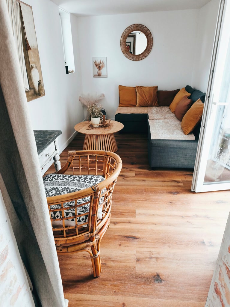 Salon lumineux avec canapé convertible et espace de vie